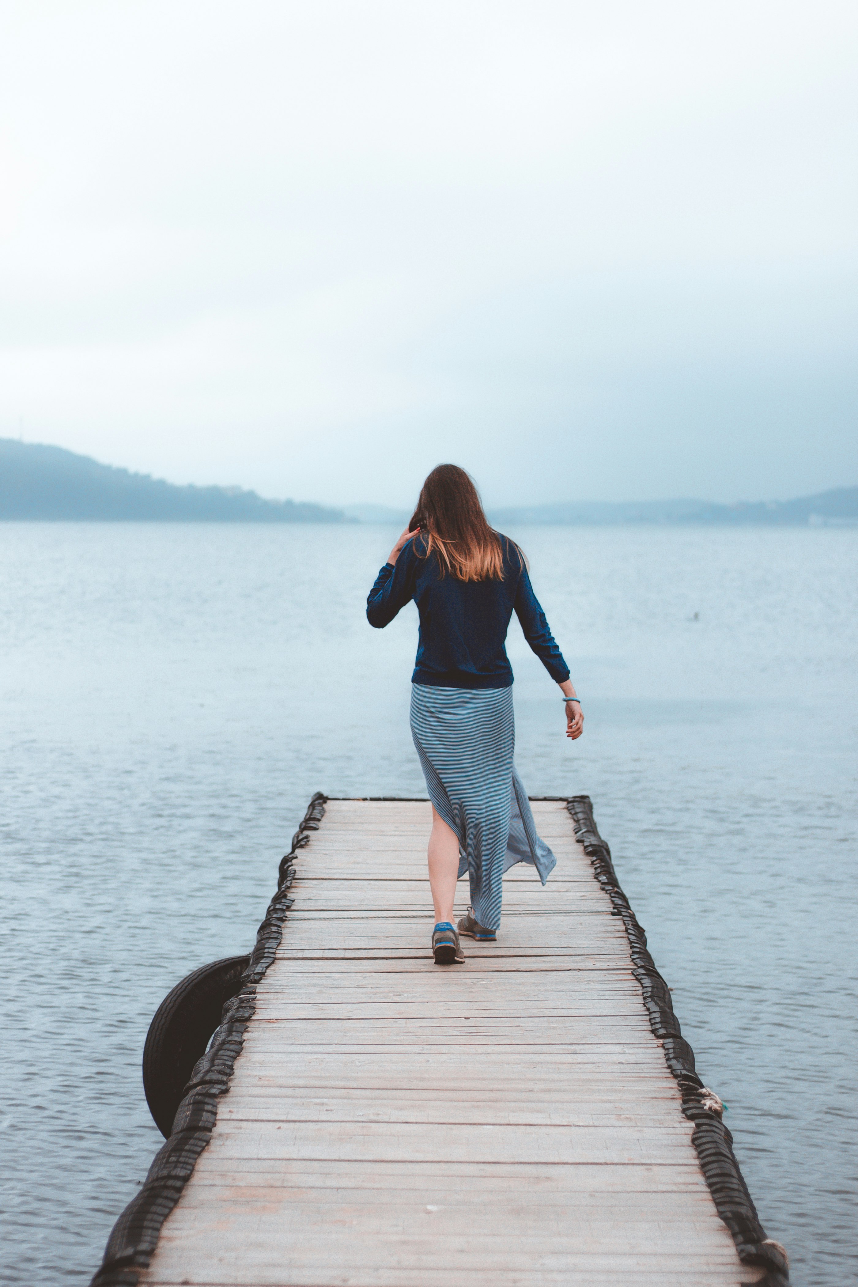 woman walking on dock near water